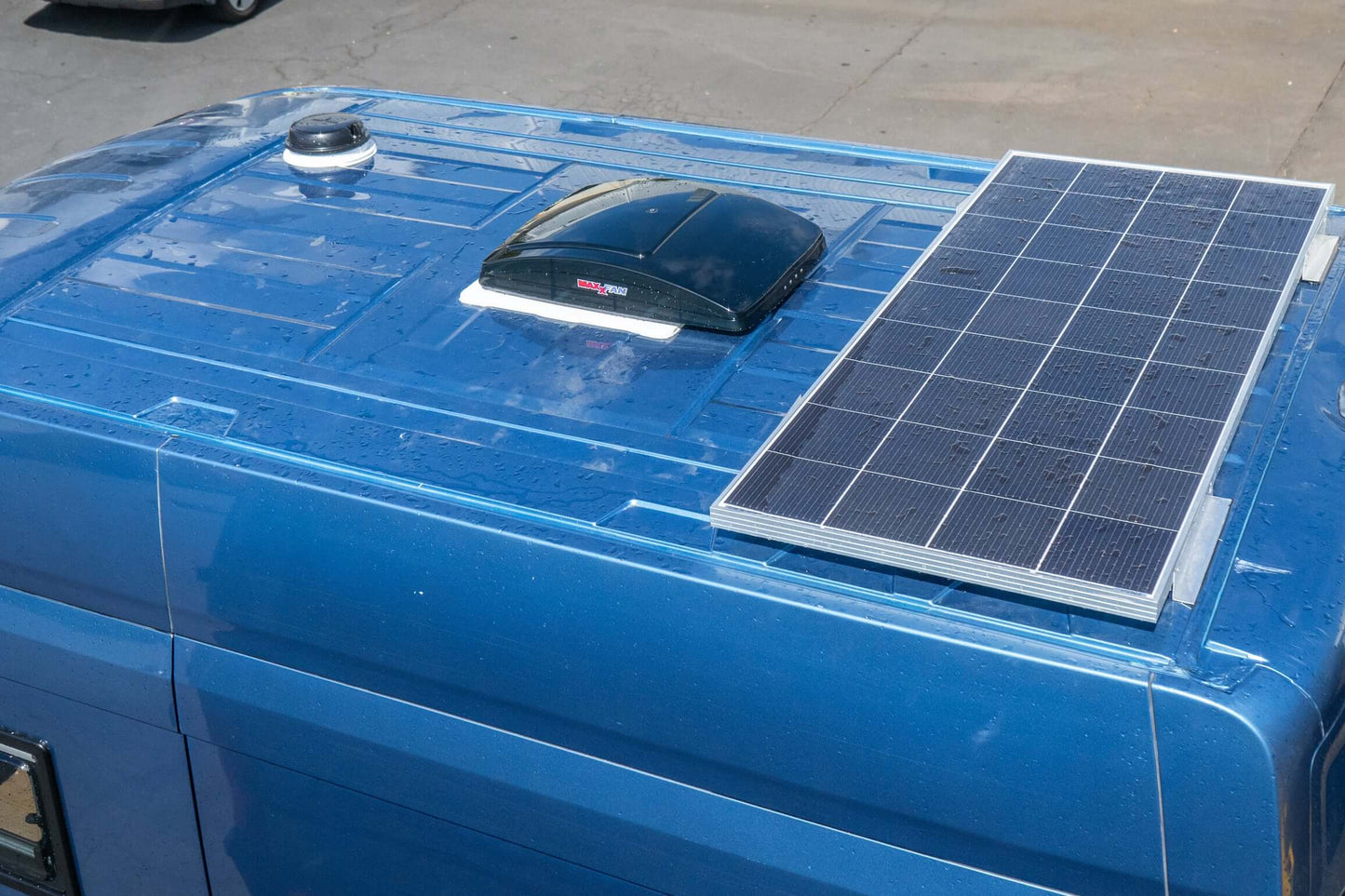 campervan roof vent installation with a solar panel on a blue campervan roof