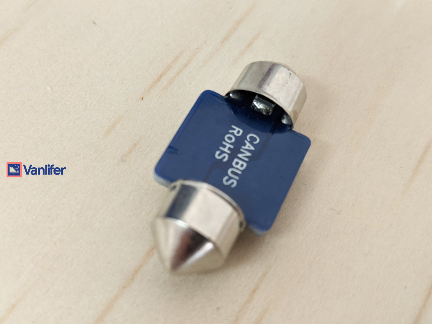 Blue and silver automotive bulb on a beige background.