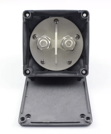 Mechanical component with metallic parts inside a black plastic enclosure on a white background