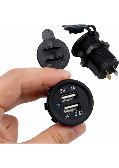 Black car charger with dual USB ports held by a hand on a white background