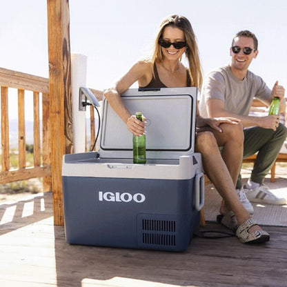 Couple enjoying drinks from the Igloo ICF18 Portable Fridge/Freezer on a deck, showcasing its convenience and portability.