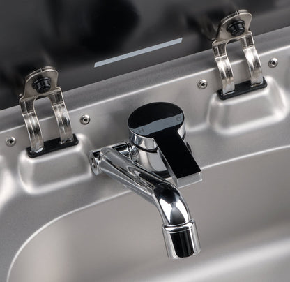 Close-up of a metallic faucet with two handles on a sink.