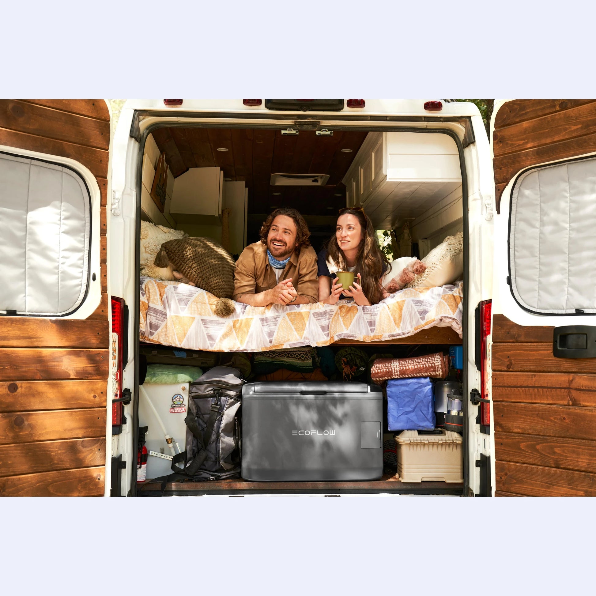 EcoFlow Glacier Portable Fridge Freezer inside campervan conversion with couple relaxing, perfect 12V campervan fridge