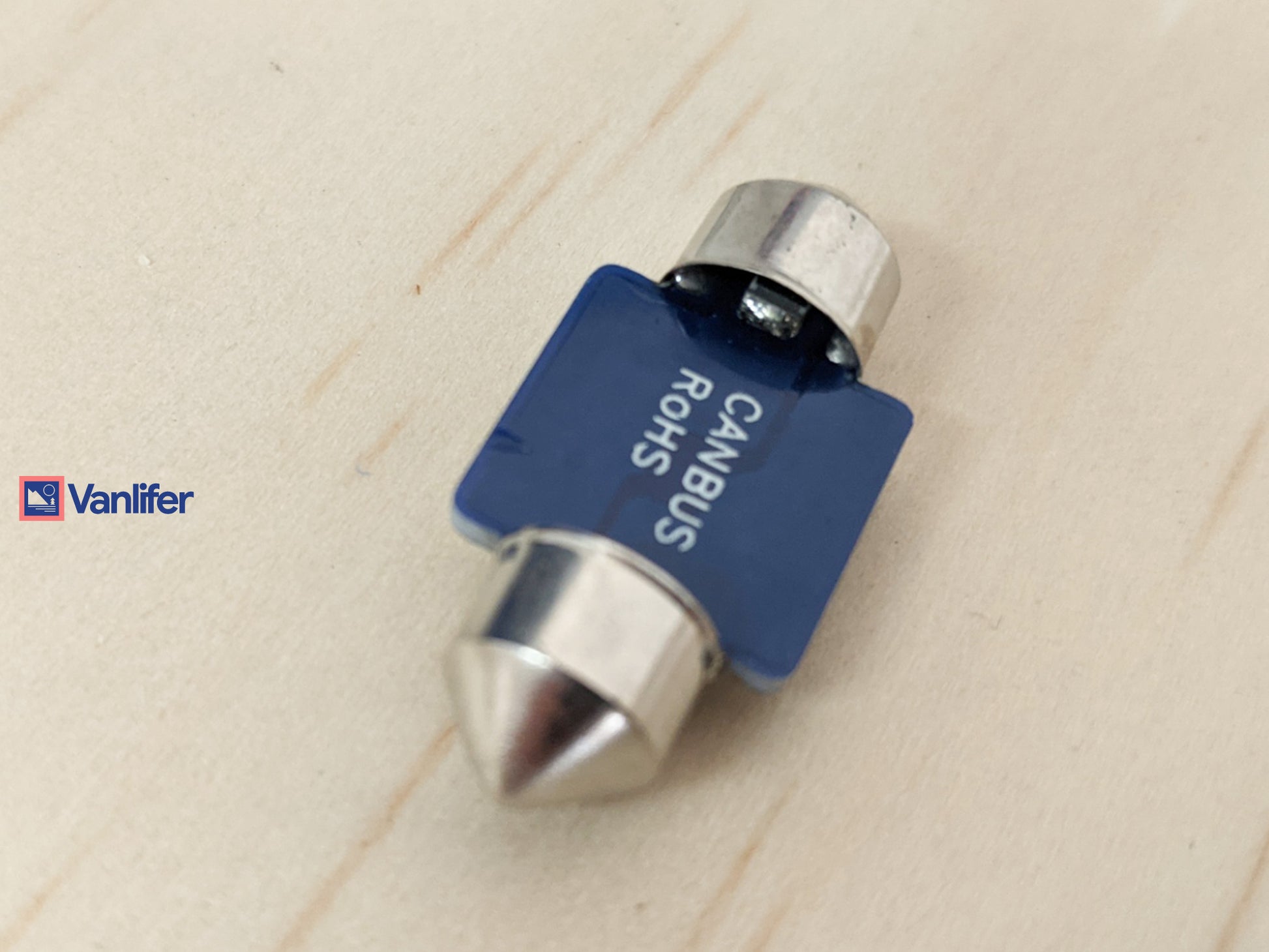 Blue and silver automotive bulb on a beige background.