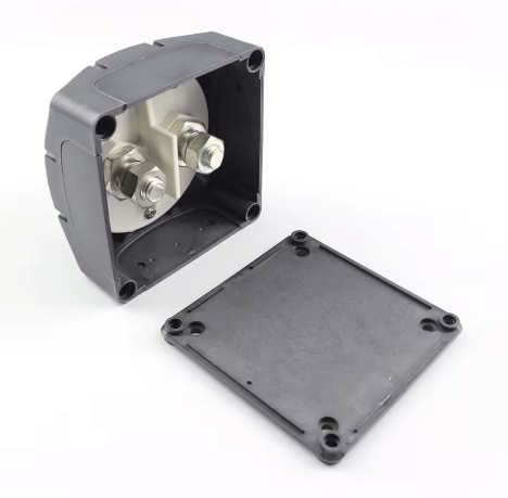 Black electrical junction box with metallic components on a white background

