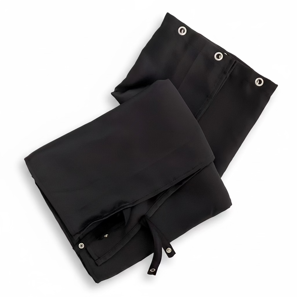 Folded black blackout campervan curtains with metal eyelets and tie backs on a white background