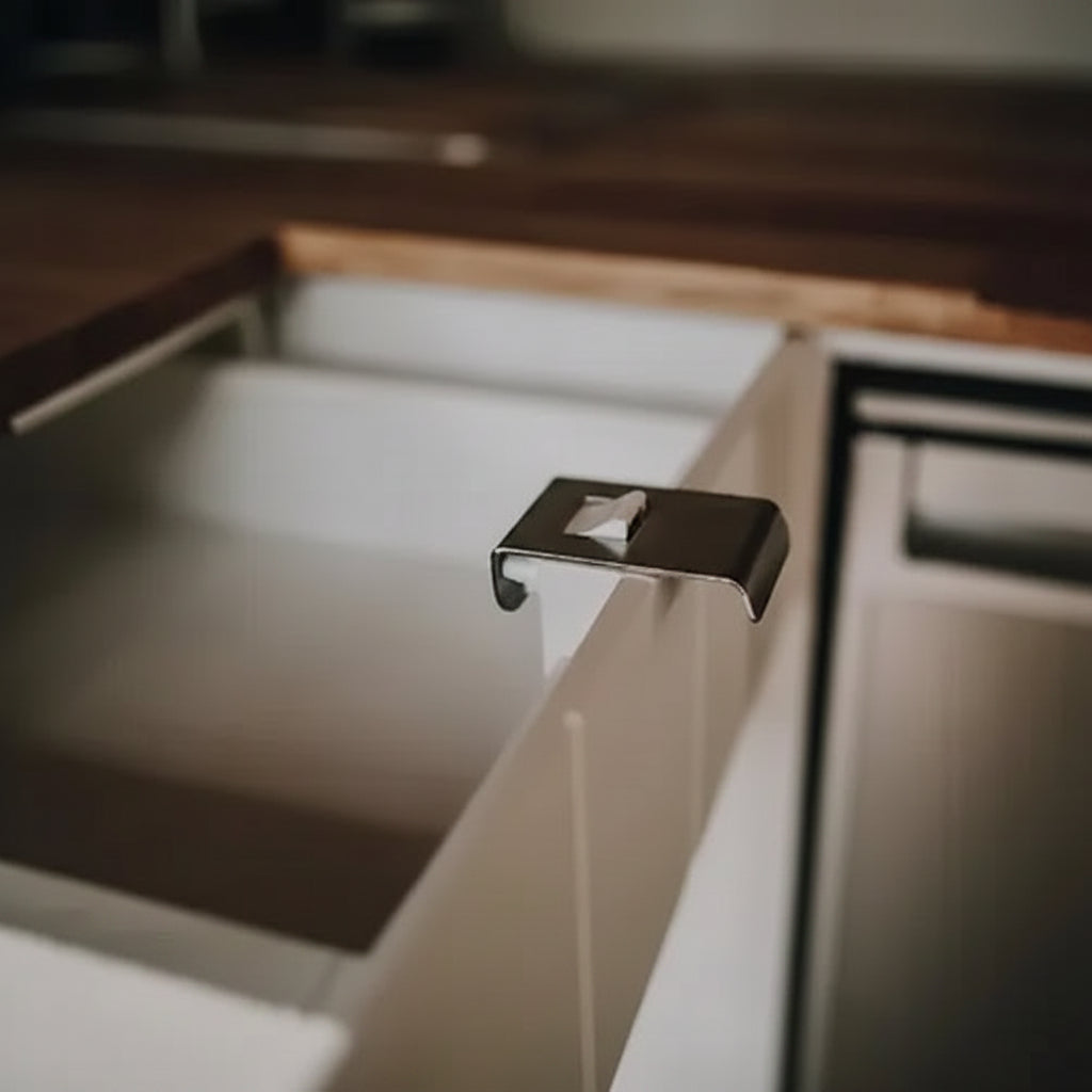 Stainless steel pull latch installed on a cabinet drawer in a campervan