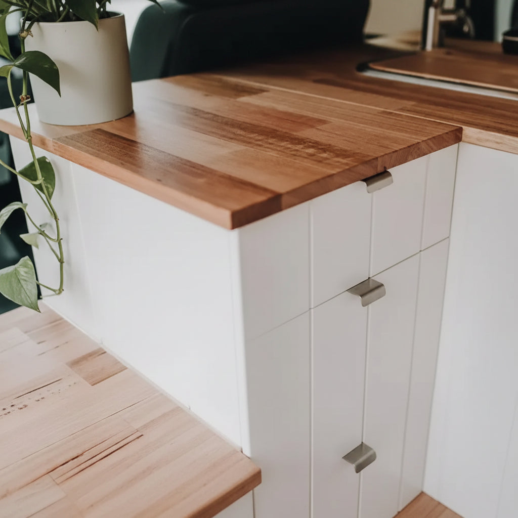 Stainless steel pull latches installed on white kitchen cabinets with timber benchtop
